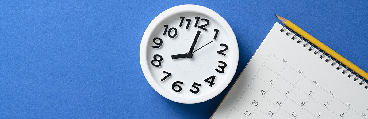A clock sits next to a calendar on a blue background.