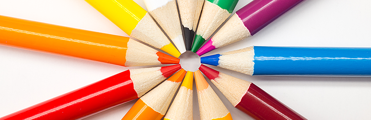 Different colored pencils arranged in a circle with the pencil points at the center, representing different choices and creativity.